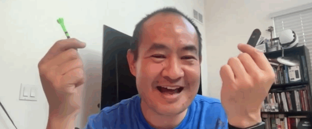 Dennis Yu smiling and holding a green stick and a black device