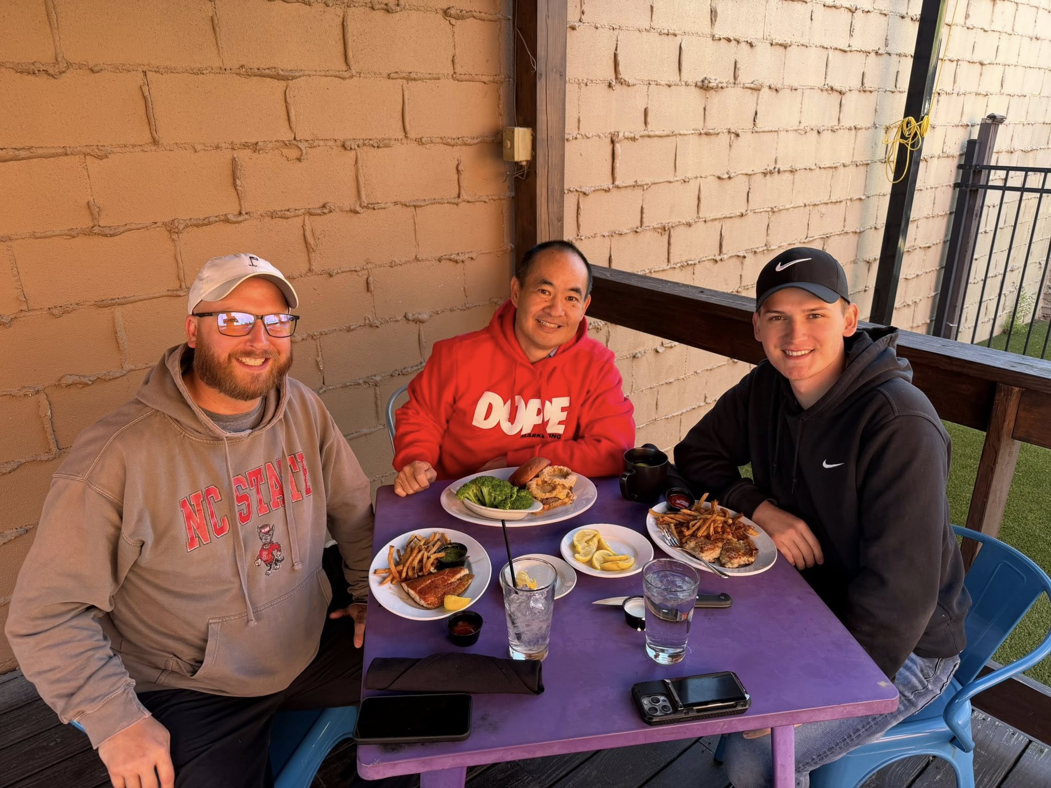 Joshua Collier, Dennis Yu, and Trent Denson sharing a meal and building real relationships