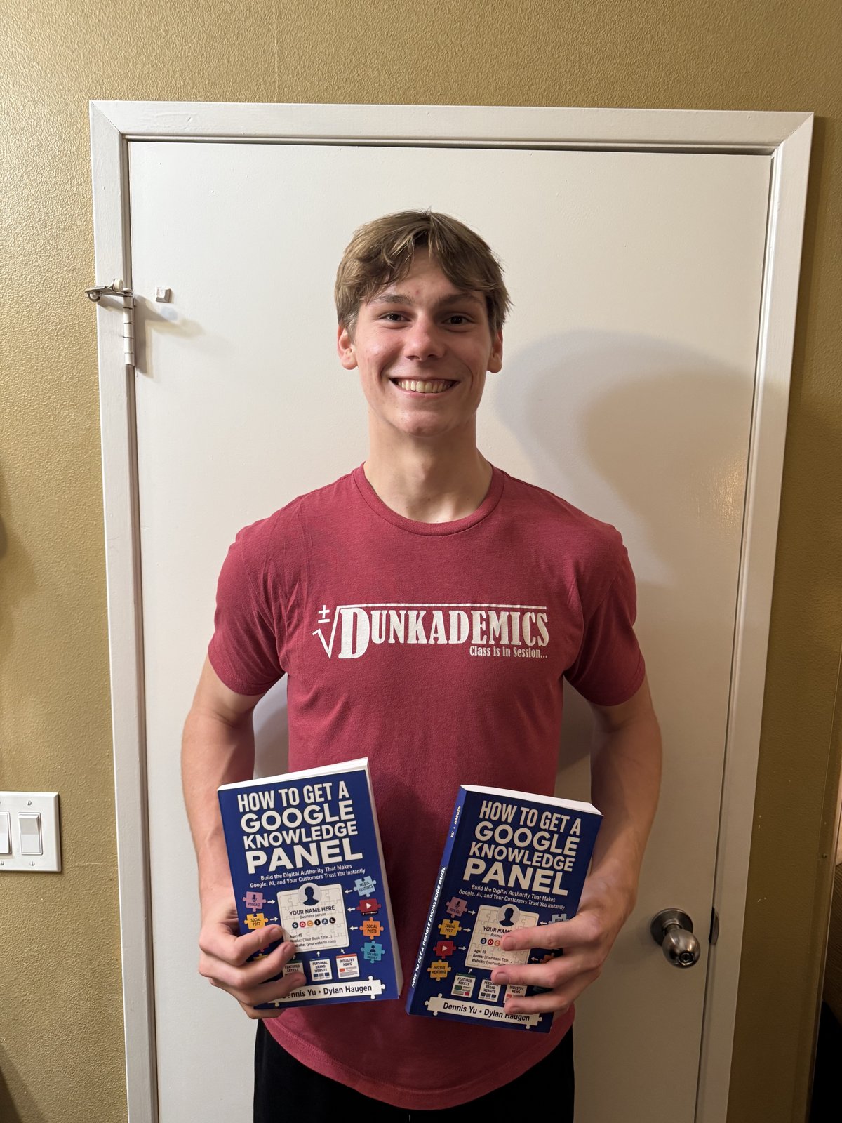 Cam Hazzard holding two copies of How to Get a Google Knowledge Panel