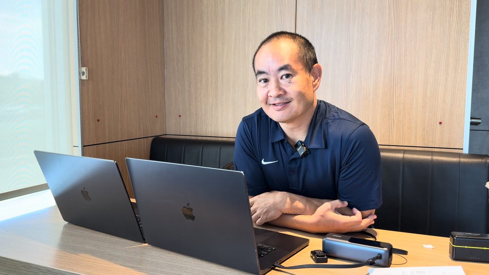 Dennis Yu with two laptops open at a table