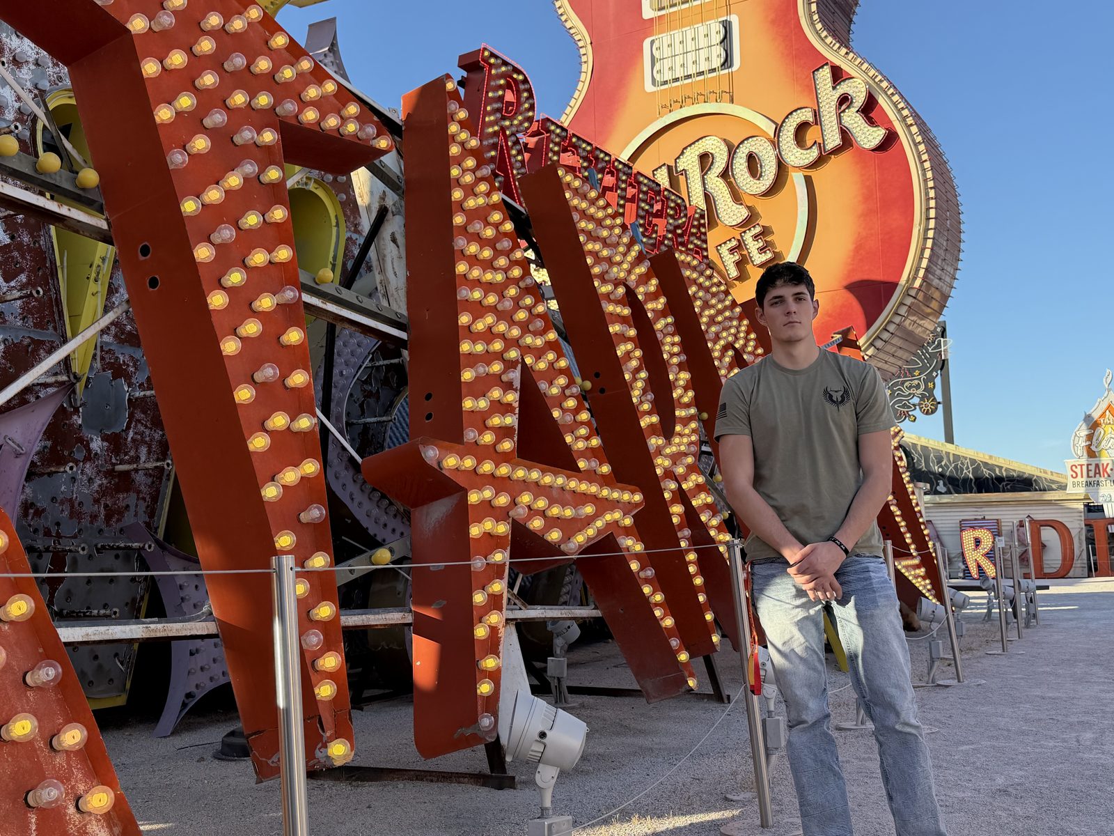 Elias beside the giant Riviera marquee letters at dusk